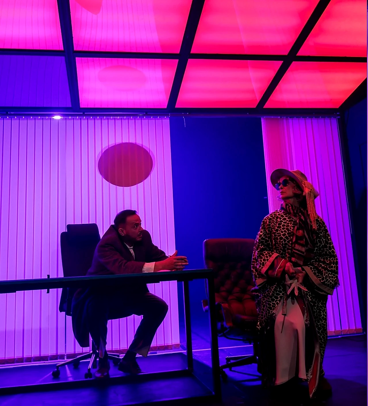 Aktoriai scenoje spektaklio metu teatriniame apšvietime